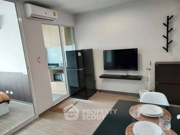 Modern apartment interior with open layout, featuring a sleek kitchen and cozy living area.