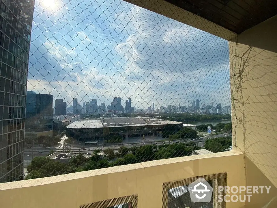 Stunning cityscape view from high-rise balcony with safety netting.