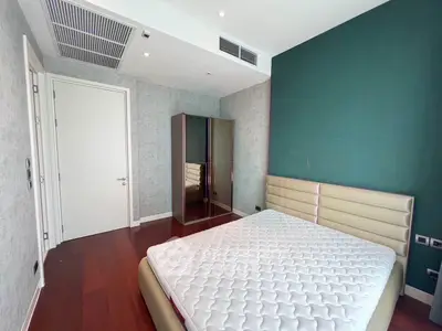 Modern bedroom with stylish design and hardwood floors, featuring a comfortable bed and sleek wardrobe.