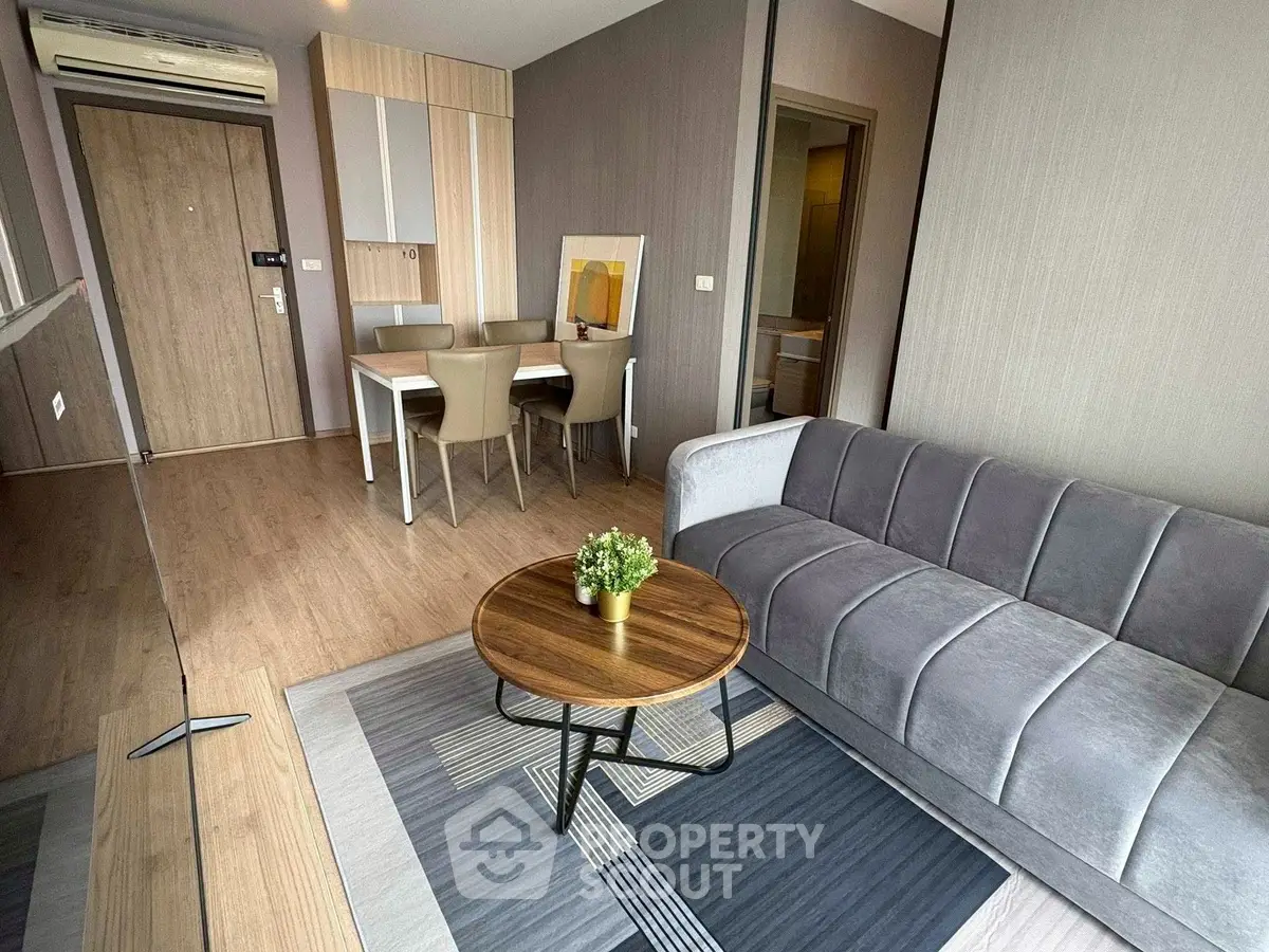 Modern living room with stylish furniture and dining area in open layout apartment.