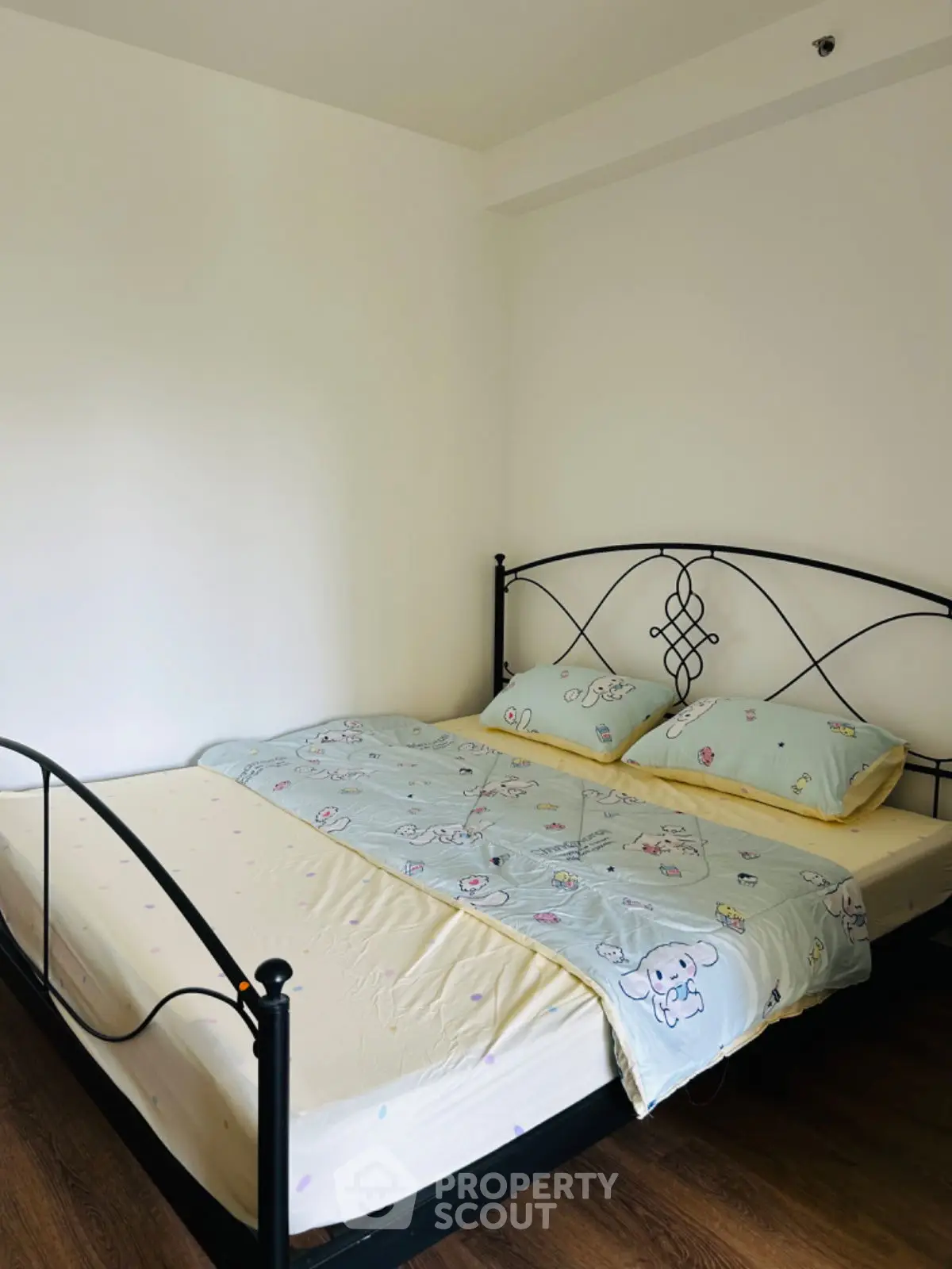 Cozy bedroom with elegant metal bed frame and soft bedding in a minimalist design.