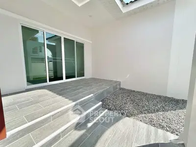 Modern patio with sliding glass doors and stone flooring in a contemporary home.