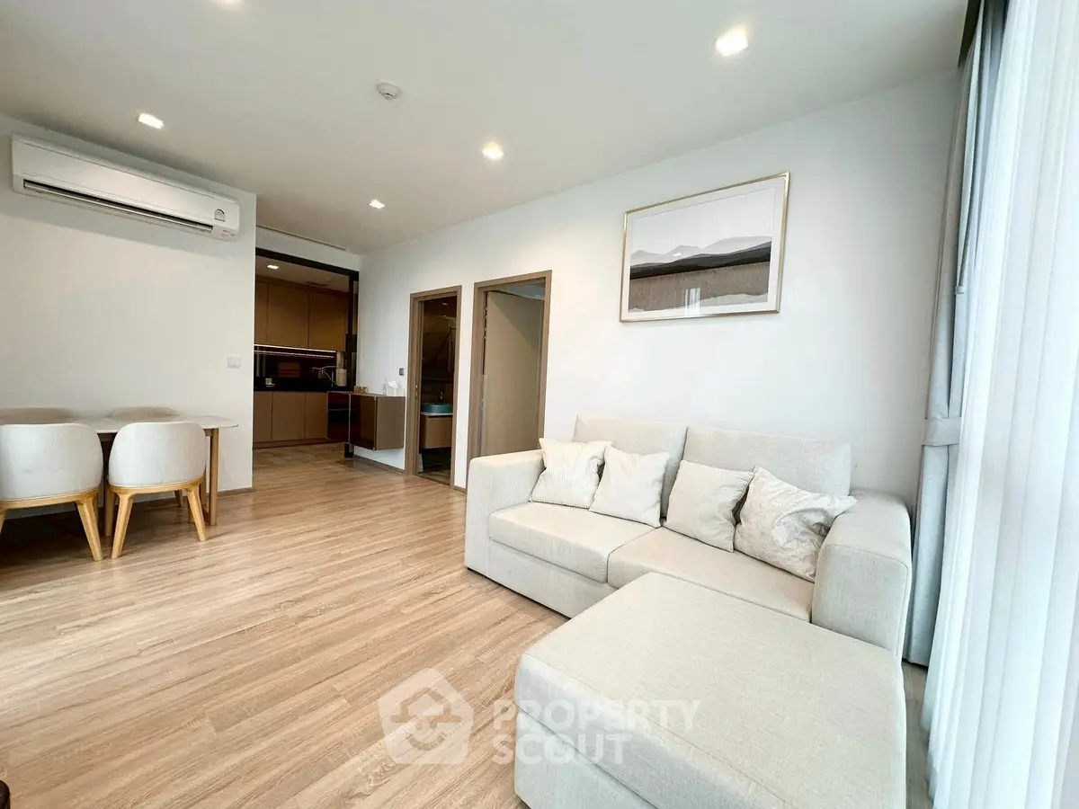 Spacious modern living room with elegant decor and open layout, featuring a cozy sofa and dining area.