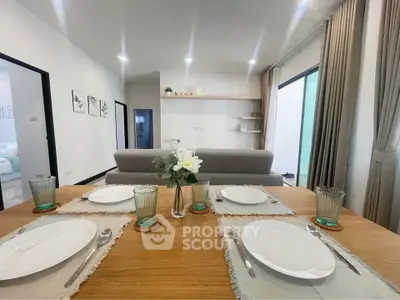 Modern dining area with elegant table setting and cozy living room view