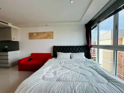 Modern bedroom with large window and red sofa in stylish apartment