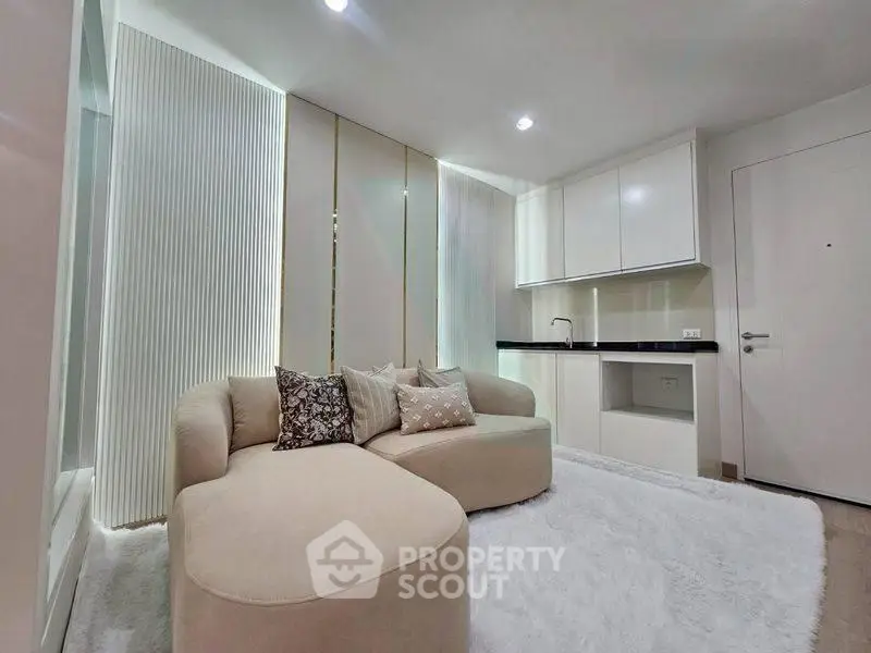 Modern living room with cozy beige sofa and sleek white cabinetry
