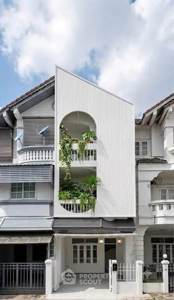 Modern townhouse with unique facade and lush balcony greenery