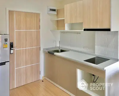 Modern kitchen with sleek cabinetry and electric stove in a compact apartment