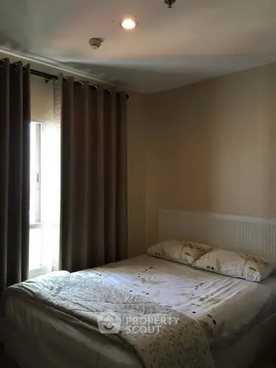 Cozy bedroom with natural light and elegant curtains in modern apartment.