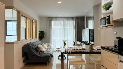 Modern living room with sleek furniture and large windows offering natural light.