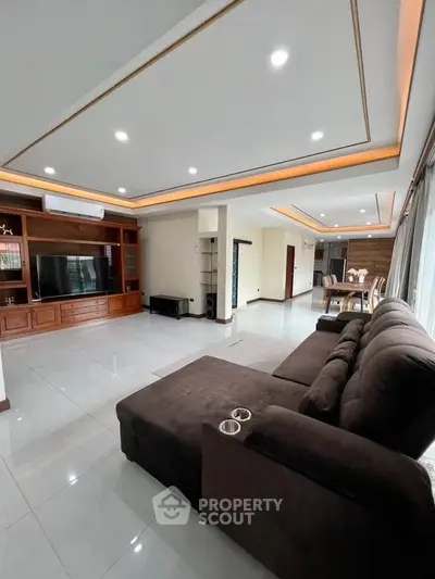 Spacious modern living room with elegant lighting and large sofa, perfect for family gatherings.