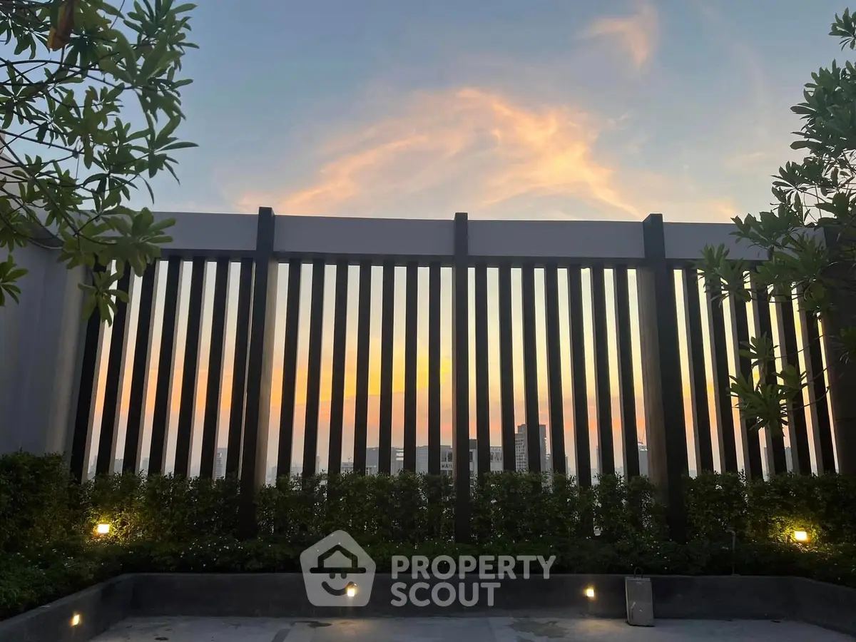 Stunning rooftop view with modern railing and sunset backdrop, perfect for urban living.