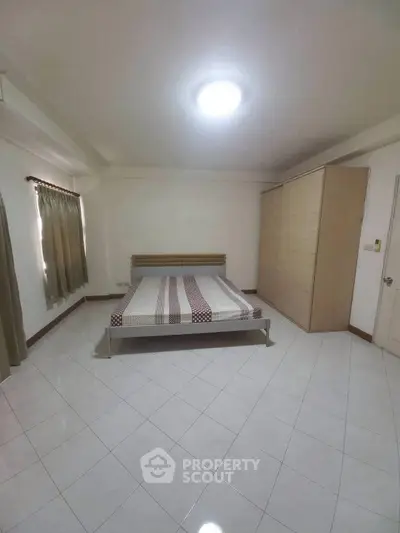 Spacious bedroom with minimalist design and ample natural light