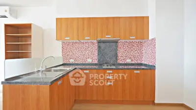 Modern kitchen with wooden cabinets and stylish backsplash in a bright apartment.