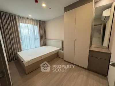 Modern bedroom with large window and sleek furniture in a stylish apartment.
