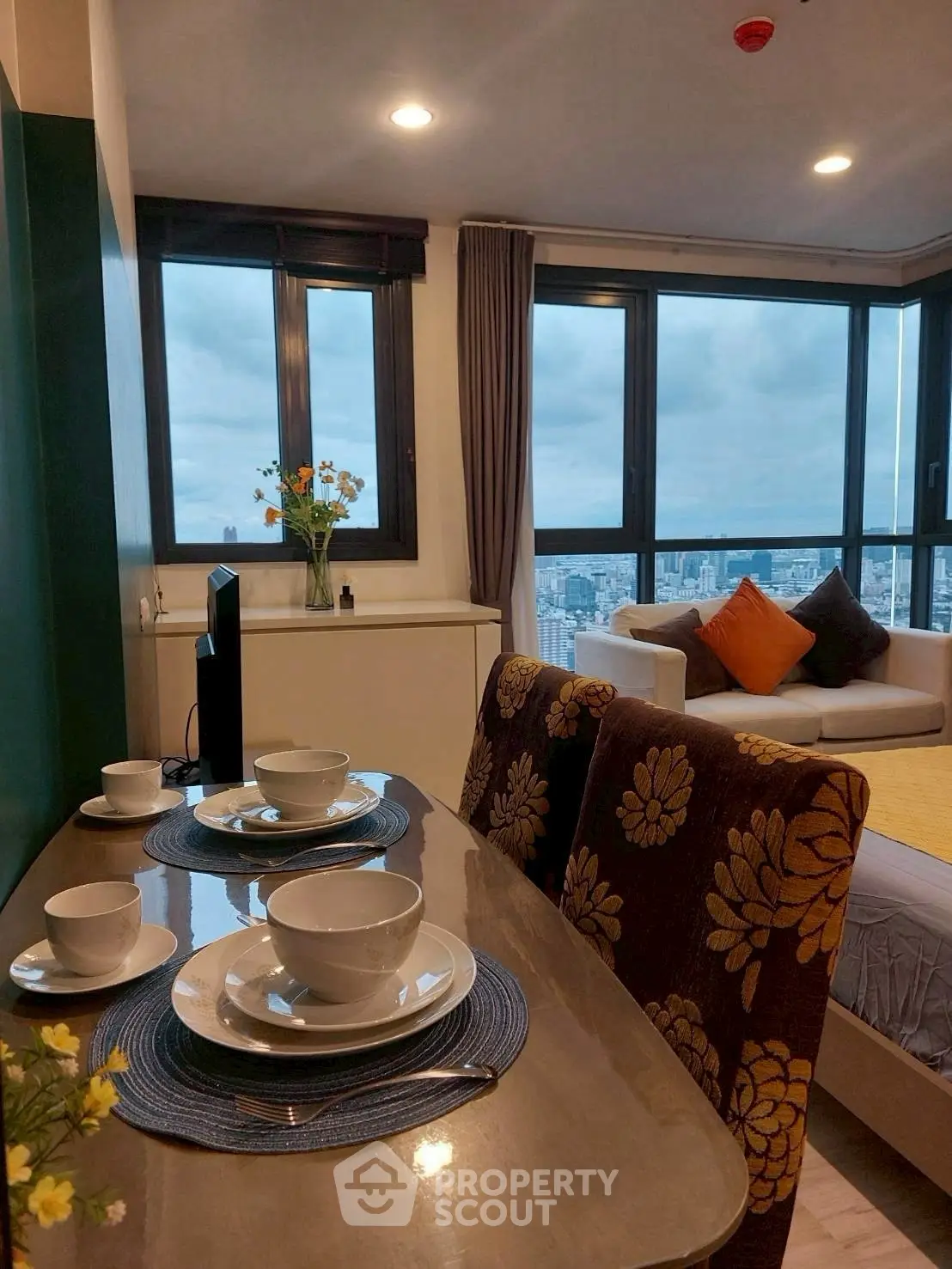 Stylish modern living room with city view, cozy dining area, and elegant decor.