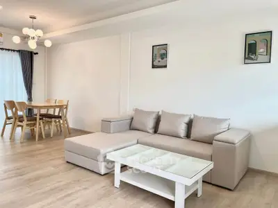Spacious modern living room with stylish furniture and dining area, perfect for family gatherings.