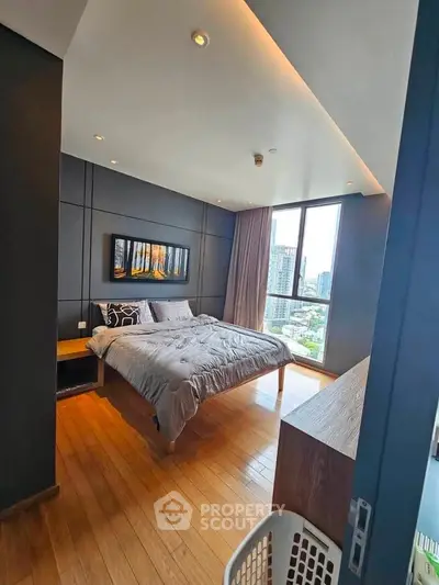 Luxurious bedroom with city view, modern decor, and wooden flooring in high-rise apartment.