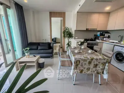 Modern open-plan living room and kitchen with sleek furniture and appliances