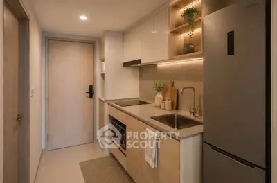 Modern compact kitchen with sleek cabinetry and stainless steel appliances in a cozy apartment.