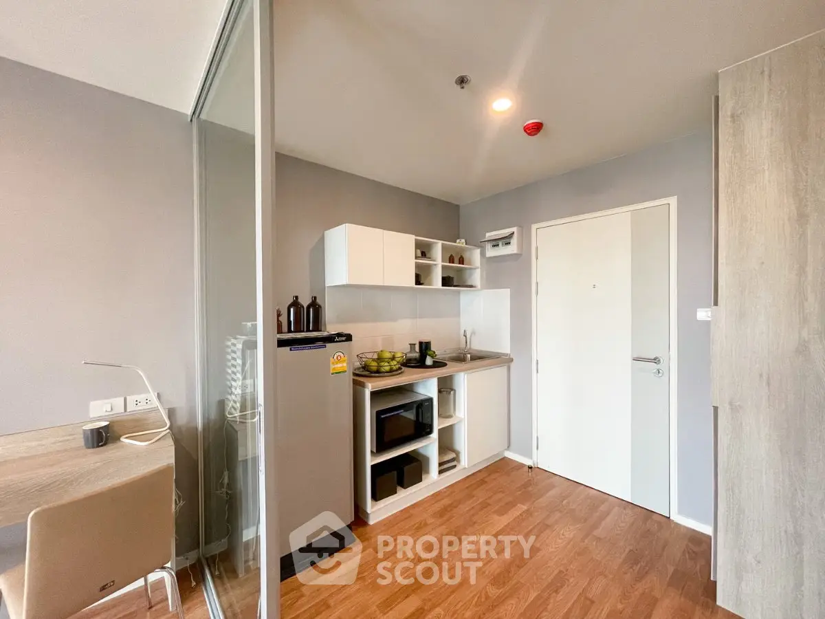 Modern kitchen with sleek design and wooden flooring in a stylish apartment