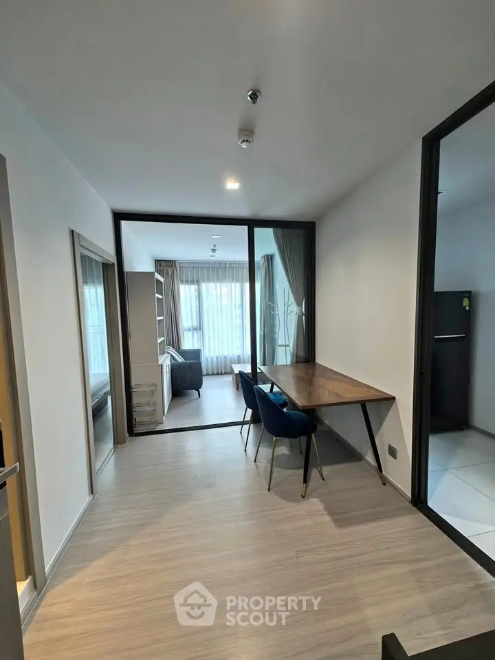 Modern apartment interior with open layout dining and living area, featuring stylish furniture and large windows.