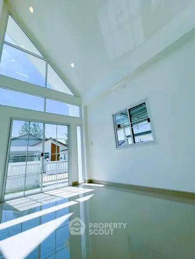 Spacious modern living room with high ceilings and large windows for natural light.