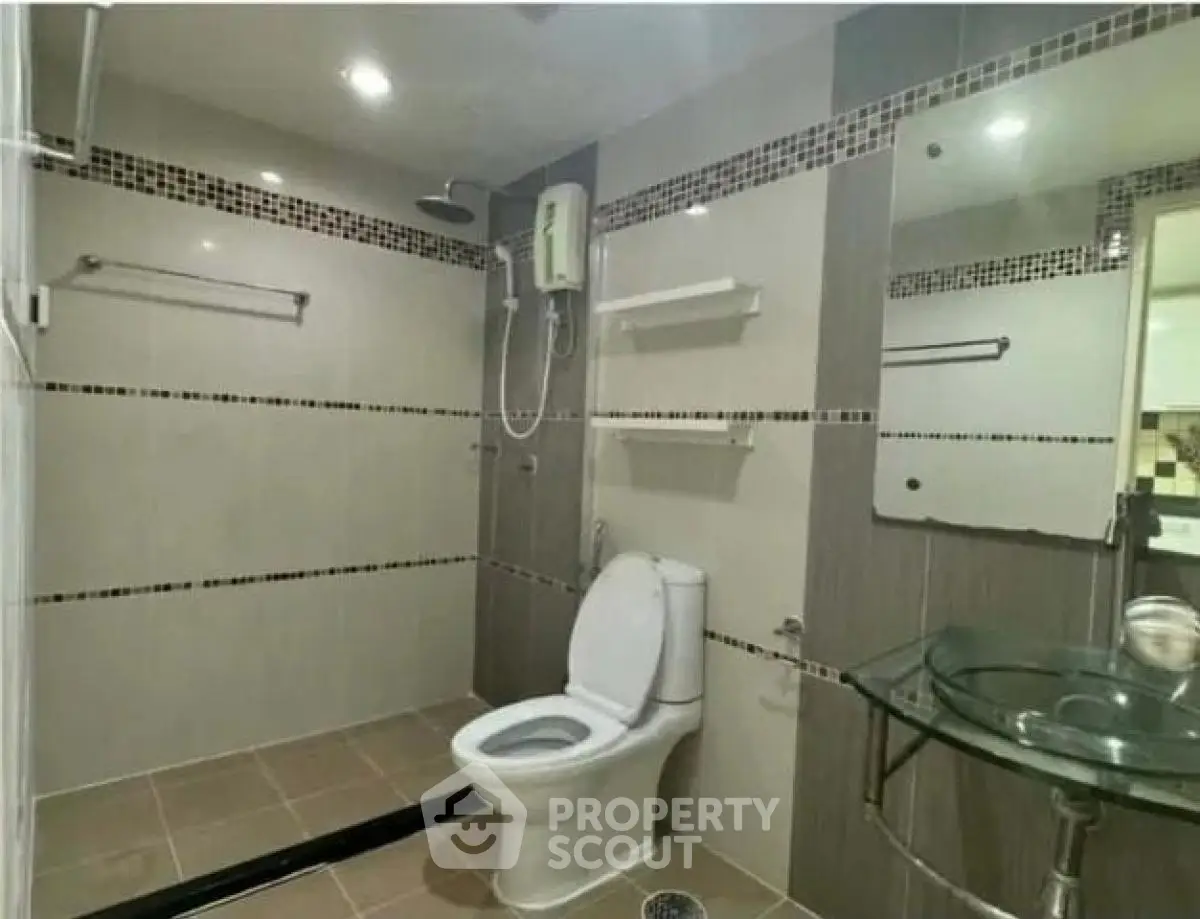 Modern bathroom with glass sink and shower in stylish apartment
