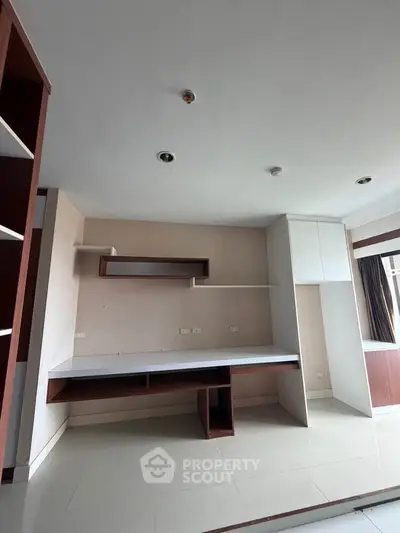Spacious study room with built-in desk and shelves, ideal for home office setup.