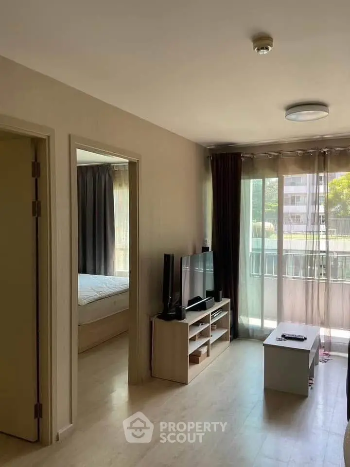 Bright living room with TV and balcony view in modern apartment