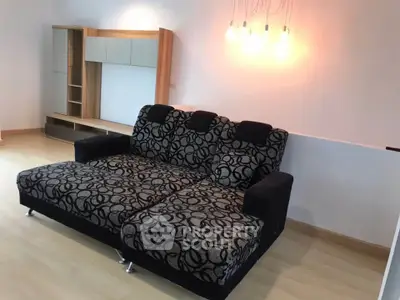 Spacious living room with modern sofa and stylish lighting, perfect for relaxation and entertainment.