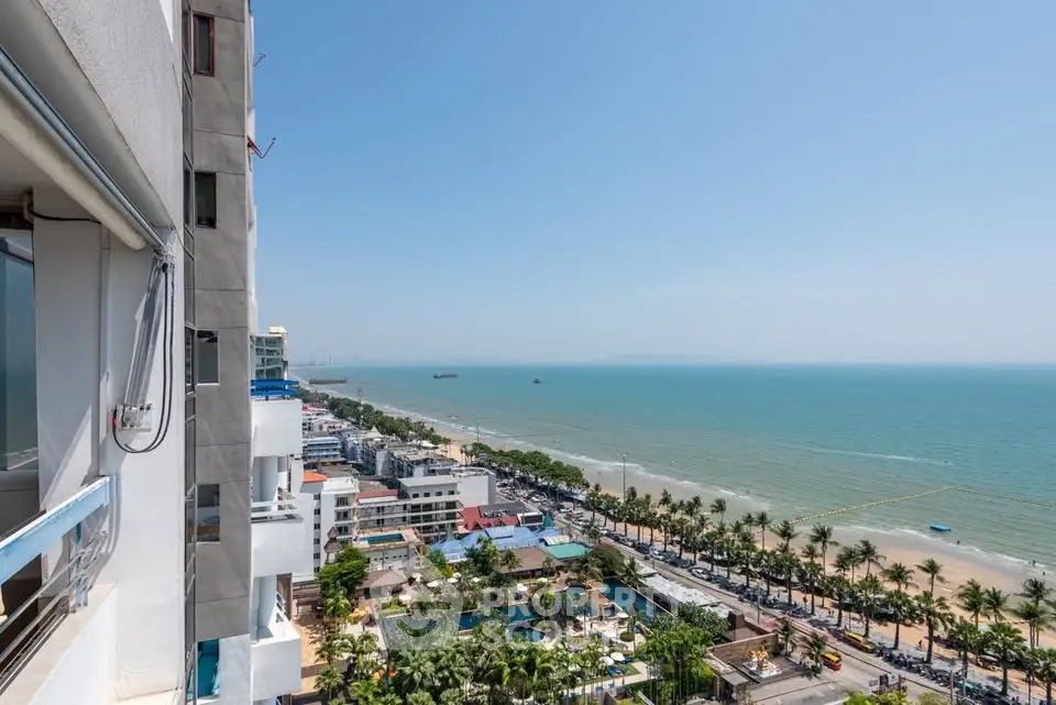 Stunning ocean view from high-rise building balcony overlooking beach and cityscape.