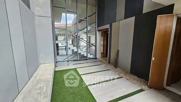 Modern building entrance with sleek design and green accents