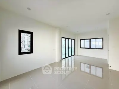 Spacious modern living room with large windows and sleek tile flooring