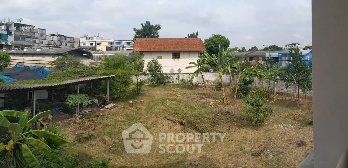 Spacious backyard with lush greenery and potential for landscaping in urban setting.