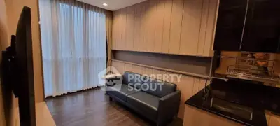 Modern living room with sleek design and large window, featuring a comfortable sofa and stylish decor.