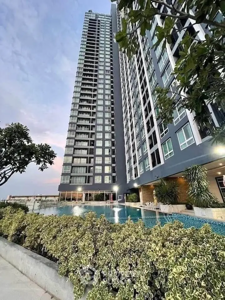 Stunning high-rise building with pool and lush greenery, perfect for luxury urban living.