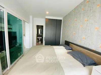 Spacious bedroom with modern decor and sliding glass doors leading to a cozy living area.