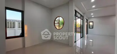 Spacious modern living area with large windows and sleek flooring, perfect for natural light and open living.