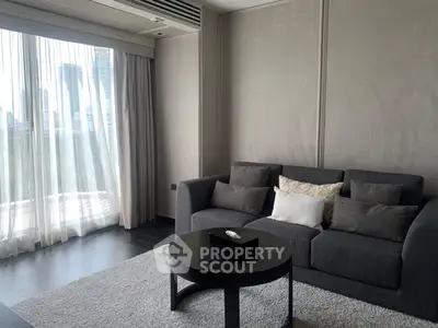 Modern living room with city view, featuring a cozy gray sofa and elegant decor.
