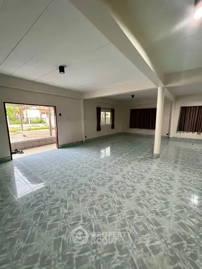 Spacious open-plan living area with tiled flooring and large windows
