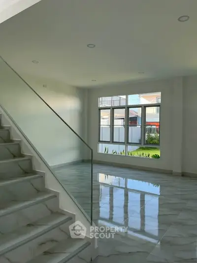 Modern interior with marble floors and large windows offering natural light.