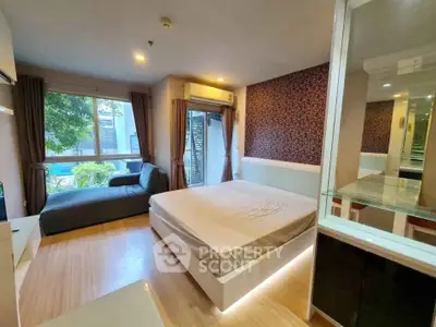Modern bedroom with large window and stylish decor in a cozy apartment.