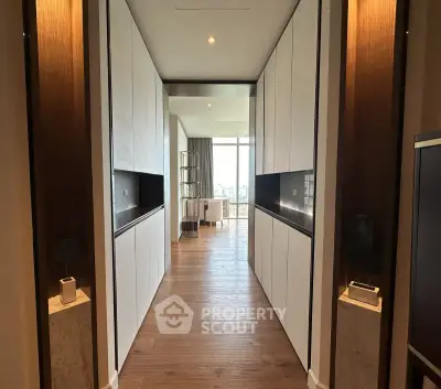 Luxurious hallway leading to a bright living area with floor-to-ceiling windows and elegant decor.