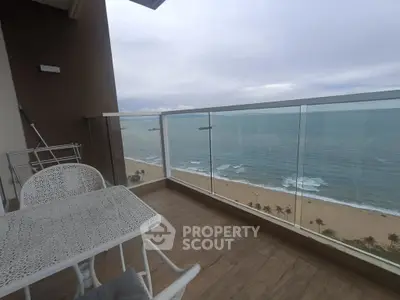 Stunning beachfront balcony with ocean view and elegant outdoor furniture.