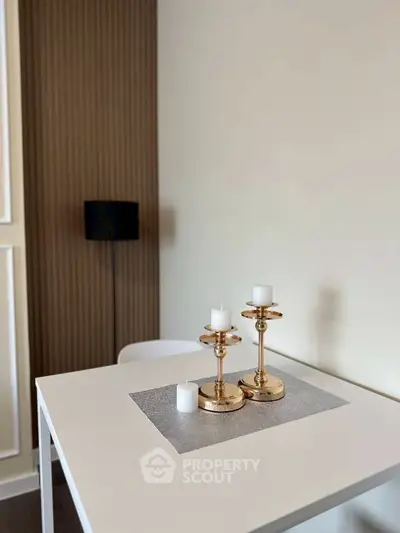 Modern dining area with elegant gold candle holders on a sleek white table
