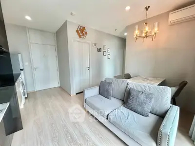 Modern living room with stylish decor and dining area in a cozy apartment.