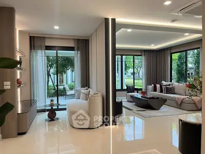 Luxurious modern living room with elegant decor and large windows offering garden views.