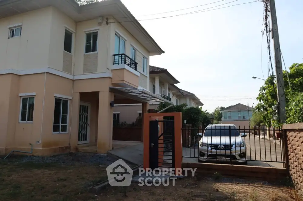 Charming two-story house with gated driveway and car parked in front, ideal suburban living.