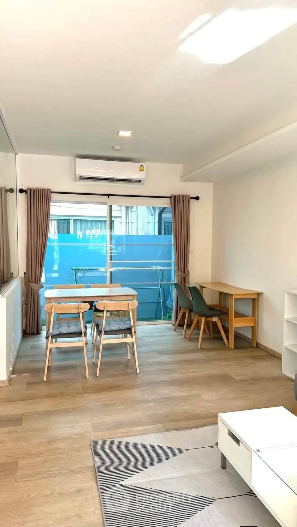 Bright modern living room with dining area and large window in a stylish apartment.